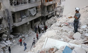 A Syrian civil defence volunteer stands on the rubble of destroyed buildings following an airstrike on eastern Aleppo this month