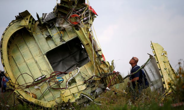 A Malaysian air crash investigator inspecting the crash site.