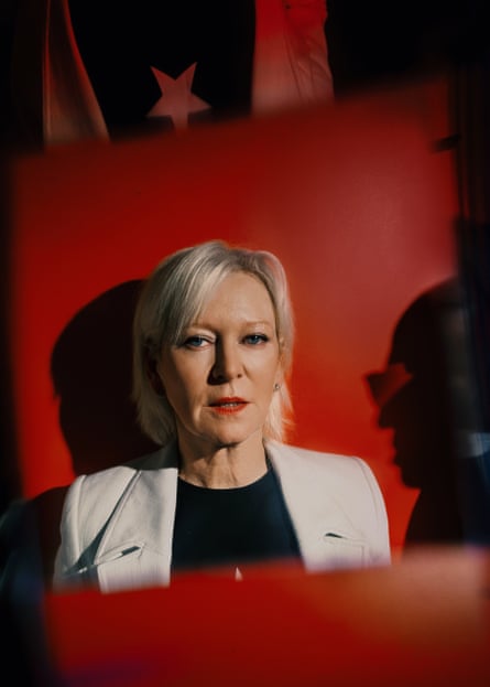 A woman poses against a red backdrop
