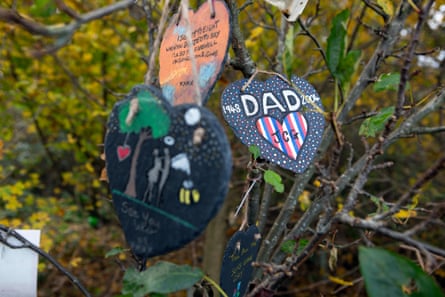 Heart-shaped memorials on string hang from a tree