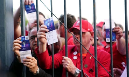 Liverpool fans stuck outside the ground show their match tickets off at the Stade de France, Paris.