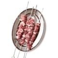 Uncooked lamb skewers on a silver plate