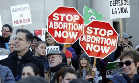 Participants hold signs at an anti-abortion rally. Trump’s ‘gag rule’ executive order could put $9.4bn in US health aid at risk, campaigners say.