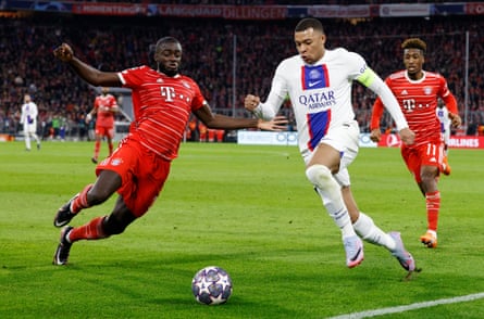 Dayot Upamecano bersiap untuk menangani Kylian Mbappé saat Bayern Munich memenangkan Liga Champions di kandang dari PSG bulan lalu.