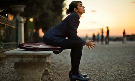 Pensive young businesswoman sitting on a stone bench at sunset