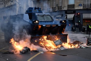 A Gendarmerie armoured vehicles (VBRG) drives past fire near the Champs Élysées