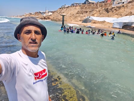 Amjed Tantesh takes a selfie while a swimming class takes place behind him