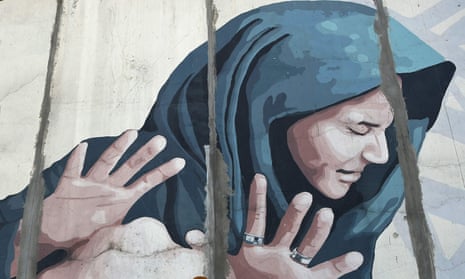 A mural showing a woman in a blue headscarf looking away and holding up her hands defensively.