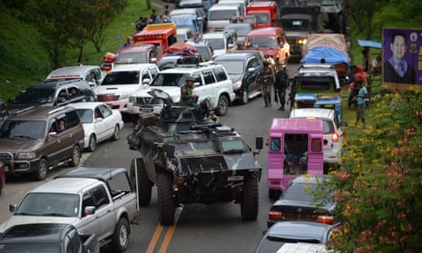 An armoured personnel carrier moves past gridlocked vehicles of residents fleeing Marawi.