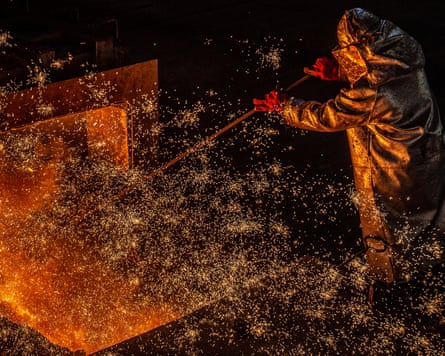 Man in protective gear as sparks fly