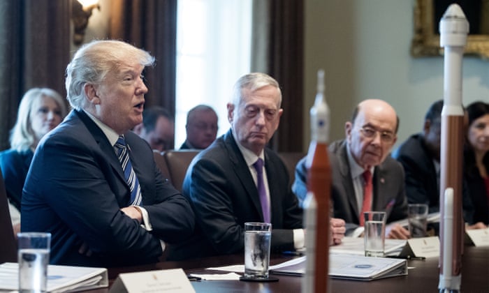 US President Donald J. Trump speaks beside US Secretary of Defense Jim Mattis and US Commerce Secretary Wilbur Ross, with rocket models on the table.