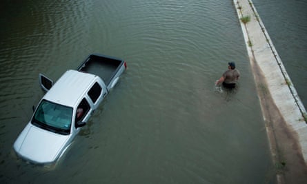 A driver walks past an abandoned truck while checking the depth of an underpass during the aftermath of Hurricane Harvey in Houston, Texas, on 28 August 2017.