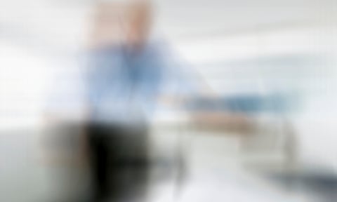 blurry image of a doctor looking down at a patient in a hospital bed