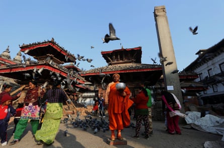 A Buddhist monk waits for alms in Durbar Square, a UNESCO heritage site in Kathmandu, capital of Nepal