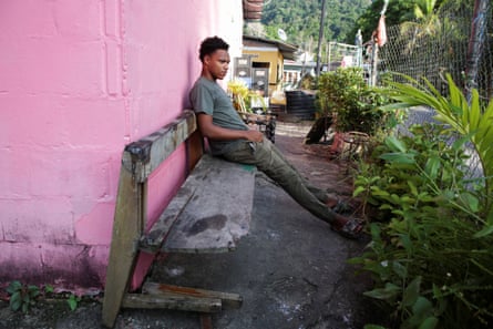 a man sits on a bench outside a house