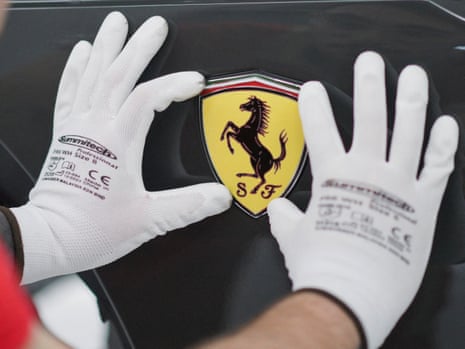 A Ferrari logo is being installed on a Ferrari car at Ferrari's new 'e-building' facility