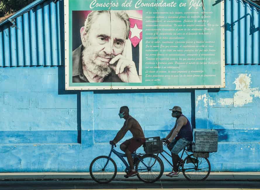 Men ride on their bicycles near a poster of Cuban late leader Fidel Castro in Havana this week.