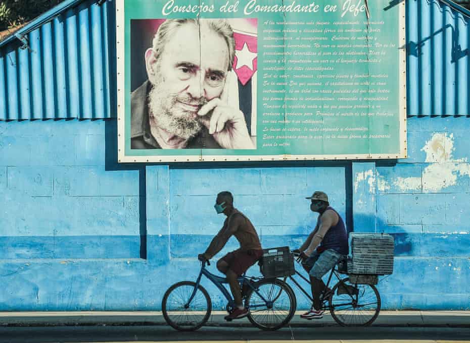 Men ride bikes near a poster of late Cuban leader Fidel Castro in Havana this week.