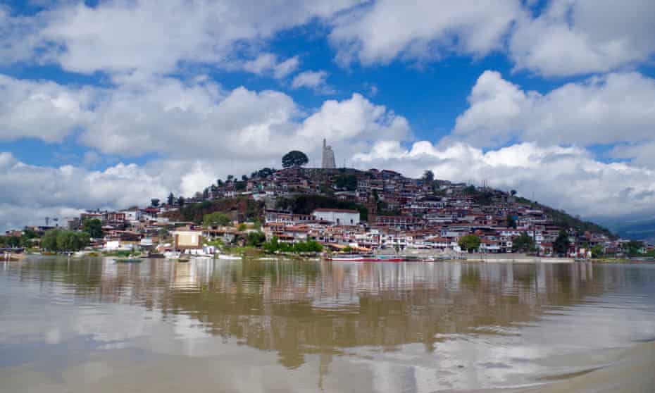 Daytime shot, with blue skies and light cloud, of Janitzio island, with José Morelos statue at its peak, Pátzcuaro, Mexico