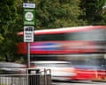 A Ulez sign with a blur of passing traffic including a London bus behind it