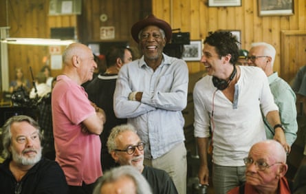The three men laugh together, surrounded by older actors