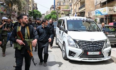 Armed members of Syria's Druze community walk along a street