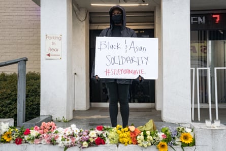 A mourner with a sign stands at one of the shooting sites in Atlanta, Georgia.