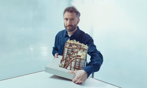 Thomas Heatherwick holding a model of a building