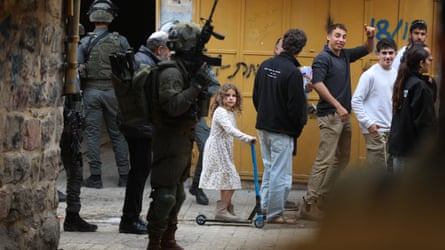 A woman connected a scooter looks up astatine a worker holding a gun
