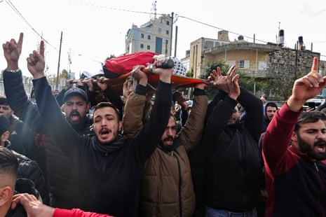 Mourners carry the body of Hazem Qatawi, who was killed during an overnight raid by Israeli forces in Ramallah, during his funeral on 28 December.