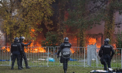 Slovenain police watch the fire at a camp for migrants near Slovenia’s border with Croatia.