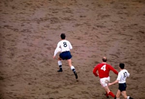 2 April 1966: Jimmy Greaves dribbling the ball on the muddy White Hart Lane pitch.