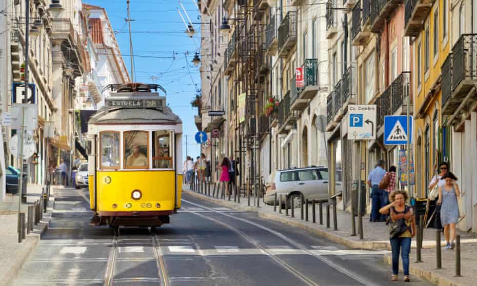 People walk down a street in Lisbon