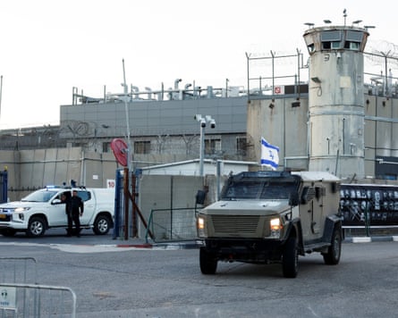 Armoured vehicle and Israeli flag next to an observation tower.