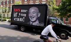 A video protest sign on a truck paid for by the Patriotic Millionaires drives past a mansion owned by Amazon founder Bezos in Washington<br>A video protest sign on a truck paid for by the Patriotic Millionaires drives past a mansion owned by Amazon founder Jeff Bezos as part of a federal tax filing day protest to demand he pay his fair share of taxes, in Washington, U.S. May 17, 2021. REUTERS/Jonathan Ernst