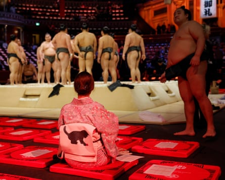 A spectator gets to her specially designed ringside cushion early to watch a stable of young fighters practising