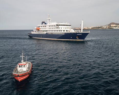 This aerial view shows a boat heading towards the port from the cruise ship MV Hondius, stationary off the port of Praia, the capital of Cape Verde.