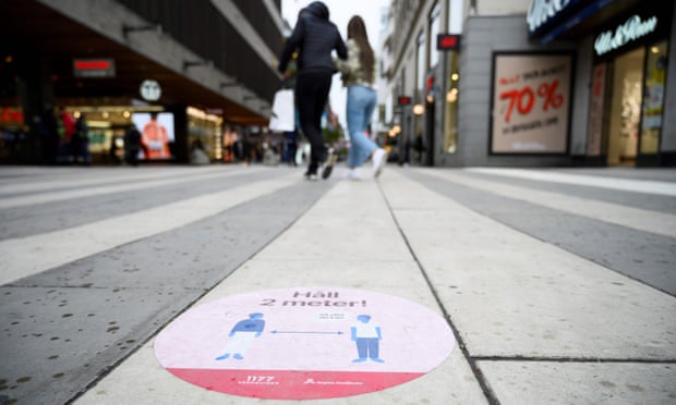 a sticker on a pavement in stockholm tells people to keep social distancing