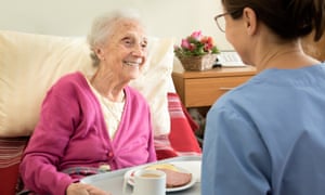 Home caregiver with senior adult woman, serving a meal