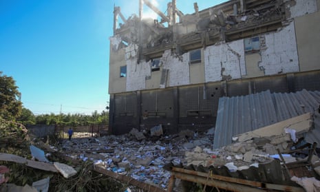 A man walks next to a printing factory damaged by a Russian missile strike in Kharkiv