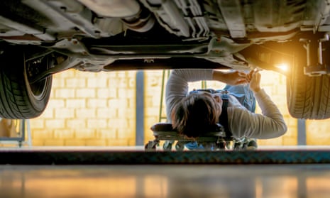 A mechanic working underneath a car