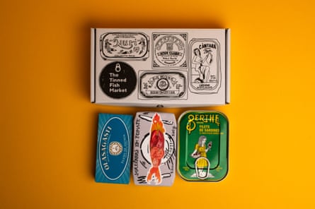 Tins of anchovies and sardines next to the gift box in which they come
