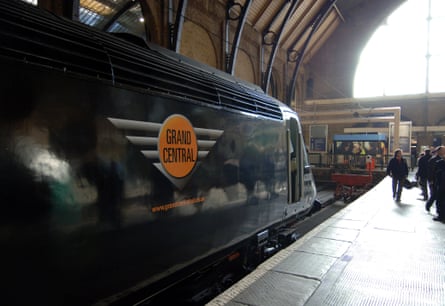 Grand Central Rail locomotive on platform at Kings Cross railway station. It is black with an orange circular logo.