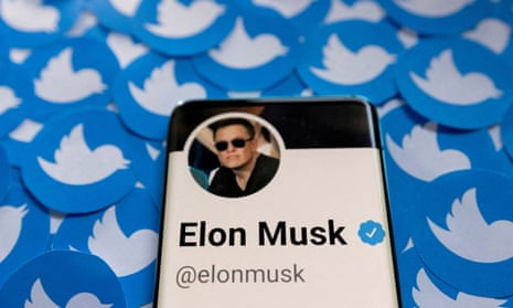 Elon musk's twitter account on phone with twitter symbol in background