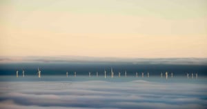 A view of Hoyle Bank windfarm in fog, with a flock of migrating birds, taken from near Holywell, Flintshire, Wales, December