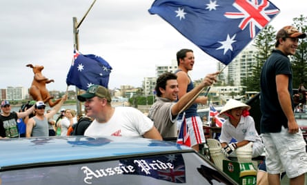 Thousands of people waving flags gather at Cronulla beach on the day the riots erupted