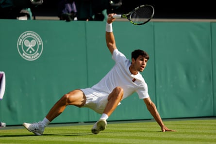 Carlos Alcaraz falls to the ground after playing a shot