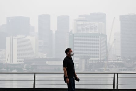 A pedestrian wearing a mask walks along the boulevard at Marina Bay, Singapore