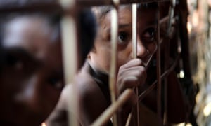 A Rohingya refugee child looks through the fence at a refugee camp in Cox’s Bazar, Bangladesh.