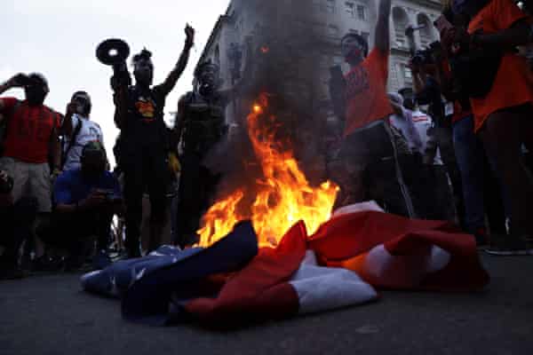 Anti-Trump activists burn a US flag near the White House, 4 July 2020 in Washington DC.